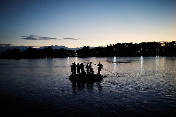 Central American migrants cross the Suchiate river into Mexico on a raft as they try to