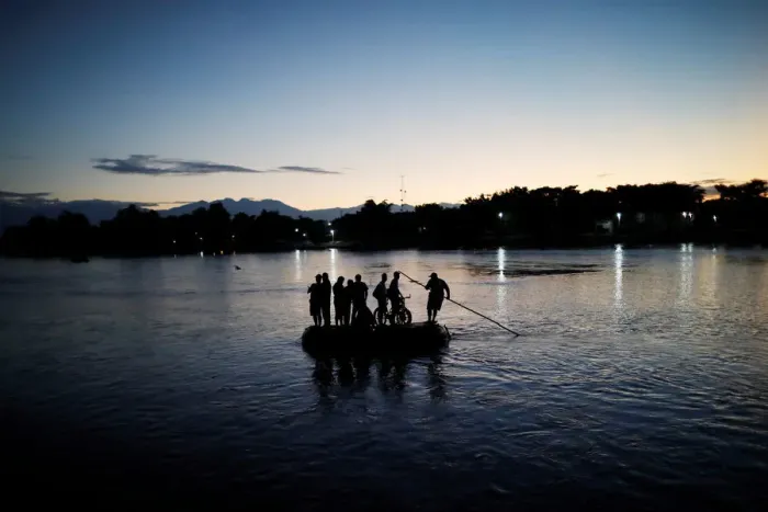 Framed Print : Central American migrants cross the Suchiate river into Mexico on a raft as they try to