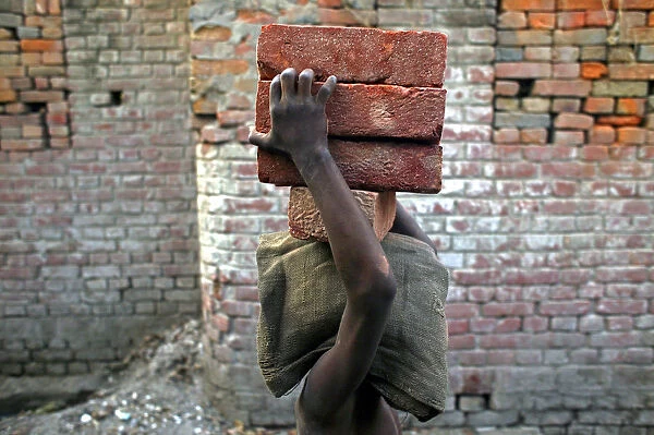 A child labourer carries bricks in Bihar-e-Sharif town