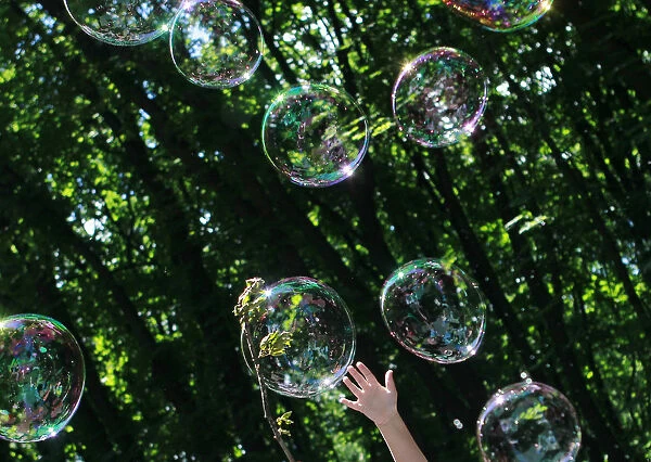 A child plays with soap bubbles at an event to support autistic children and their