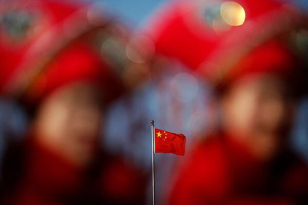 Chinas national flag is seen behind hostesses waiting for delegates outside the Great