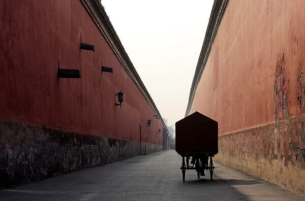 A Chinese cyclist pedals inside the Forbidden City in Beijing