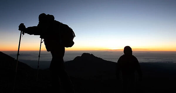 Climbers walk up the steep gravel and scree slope leading to the summit of Tanzania s