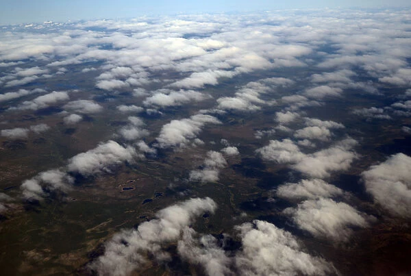 Clouds and land are seen from an atmospheric research aircraft en route to the Norwegian
