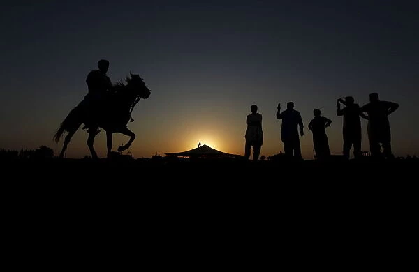 Competitors prepare for horse race as they pay homage at the shrine of the Muslim