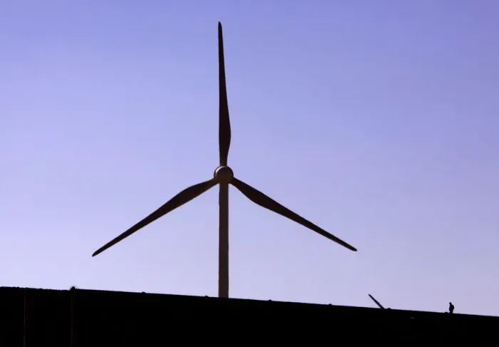 Framed Print : A construction worker walks on a new road located near a field of giant wind turbines Framed Print : A construction worker walks on a new road located near a field of giant wind turbines