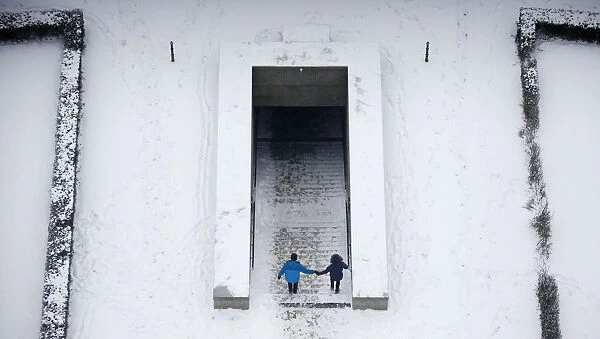 A couple descend into an underpass tunnel after heavy snowfall in Berlin