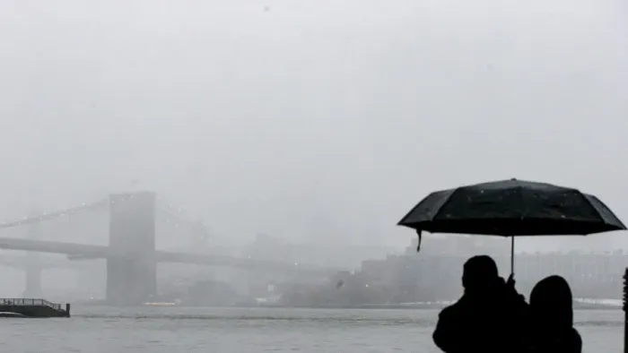 Framed Print : A couple stops to look at the Brooklyn Bridge during a winter nor easter storm in New Framed Print : A couple stops to look at the Brooklyn Bridge during a winter nor easter storm in New