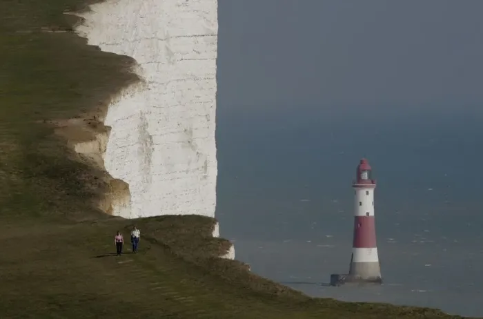 Framed Print : A couple walk along the Seven Sisters cliffs close to the Beachy Head lighthouse near Eastbourne Framed Print : A couple walk along the Seven Sisters cliffs close to the Beachy Head lighthouse near Eastbourne