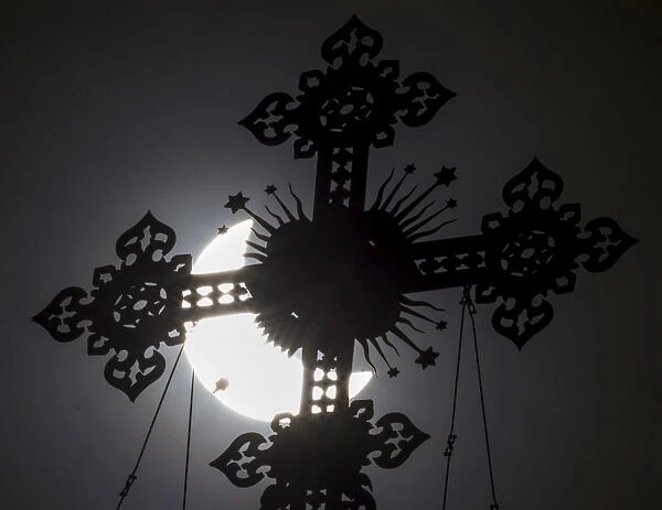A cross on the dome of the Cathedral of Christ the Saviour is seen during a partial solar