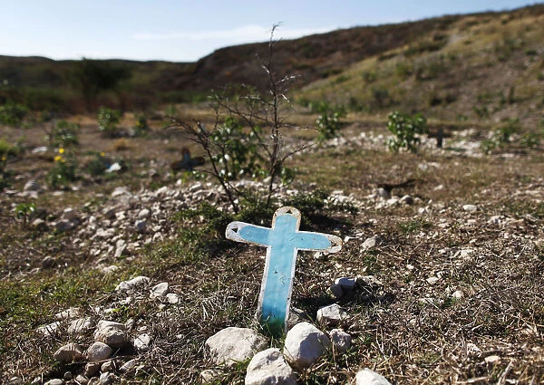 A cross is seen at a burial site for those who died of the cholera epidemic on the