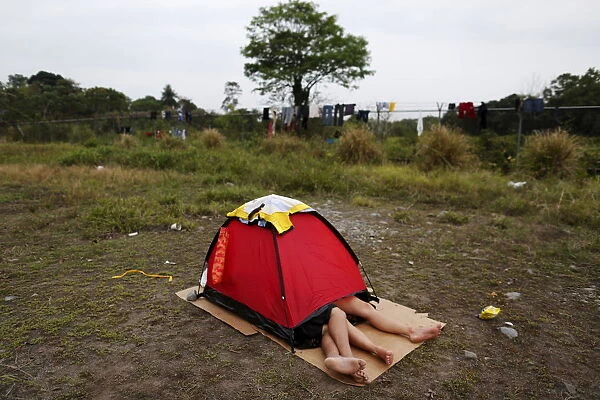 A Cuban migrant couple rests inside a tent at a provisional shelter in Paso Canoas