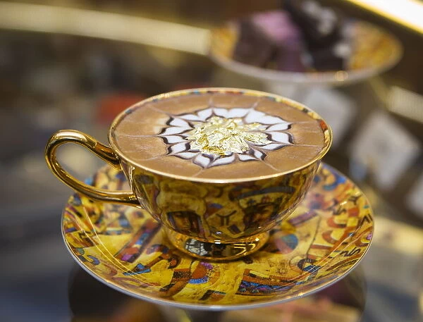 A cup of cappuccino called The Golden Horde with eatable gold flakes is ready for