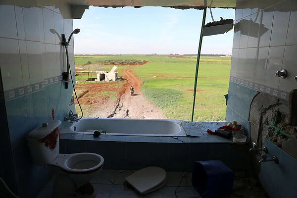 Damaged bathroom in a house, in al-Harak town, near Deraa