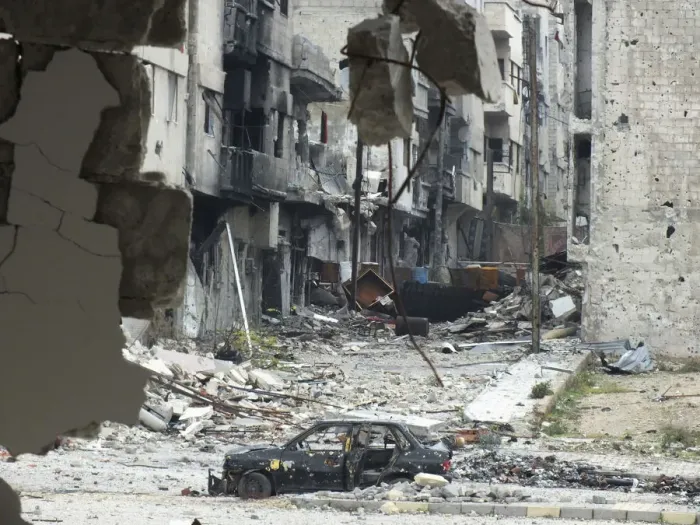Framed Print : A damaged car is seen near carpets erected as protection from snipers along a street Framed Print : A damaged car is seen near carpets erected as protection from snipers along a street