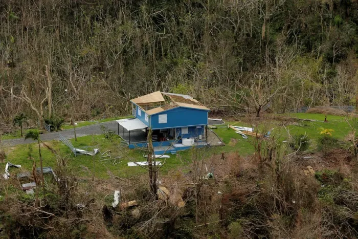 Framed Print : A damaged home is seen among blown down trees following Hurricane Maria in San Sebastian