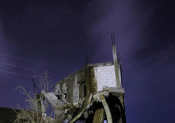 Damaged houses are pictured at night in the rebel-held area, in the city of Daraa, Syria