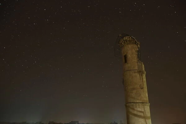 A damaged minaret is pictured at night in Aleppo, Syria