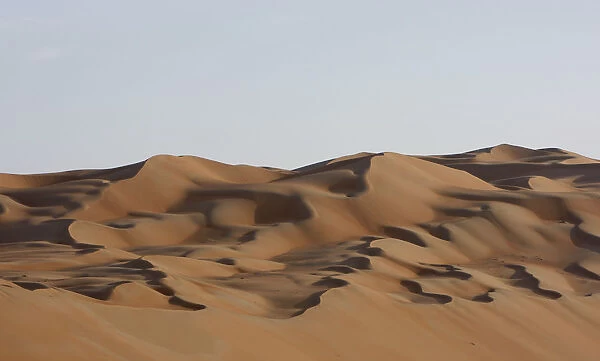 Dawn sunlight hits the dunes of the of Al Batin Near Liwa in the United Arab Emirates