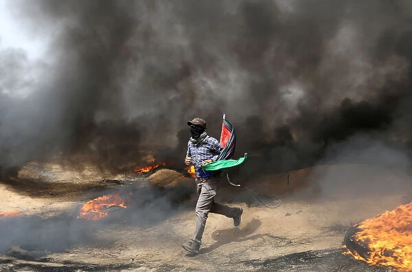 Demonstrator runs during clashes with Israeli troops at a protest where Palestinians