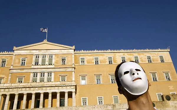 A demonstrator wearing a mask protests in front of the parliament in Athens