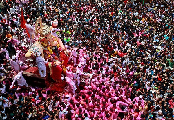 Devotees carry an idol of Hindu god Ganesh during a procession on the last day of