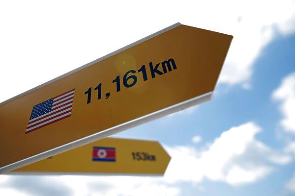 Directional signs bearing North Korean and U. S. flags are seen near the demilitarized