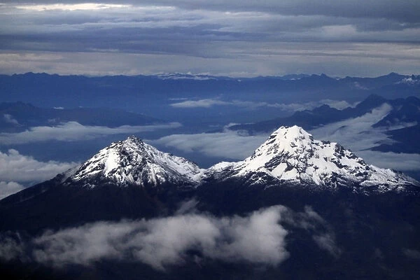 The double peak of the Illinizas are seen from a plane during a flight to Quito