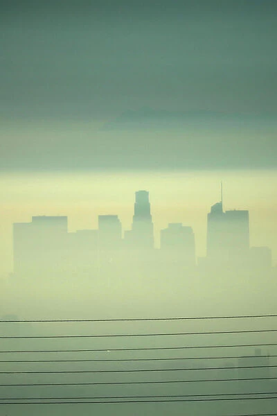 Downtown Los Angeles is seen behind electricity lines through the morning marine layer in