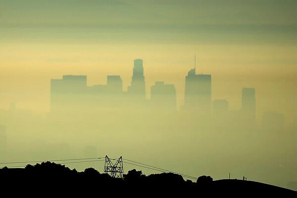 Downtown Los Angeles is seen behind an electricity pylon through the morning marine layer