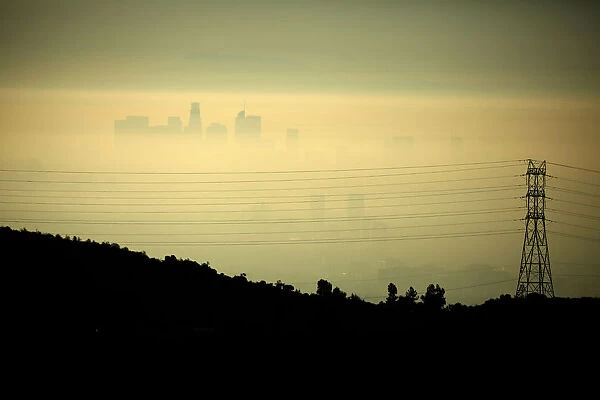 Downtown Los Angeles is seen behind an electricity pylon through the morning marine layer