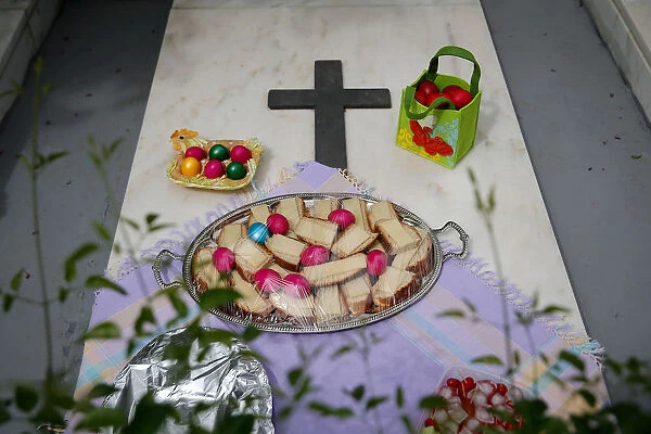 Dyed eggs and food are placed on a grave, on Saint Thomas Sunday