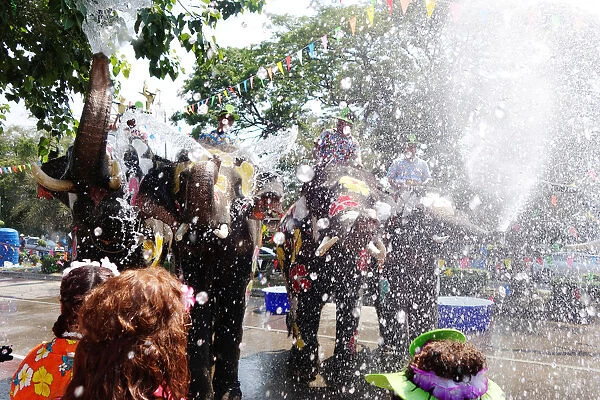 Elephants and people play with water during the celebration of Songkran Water Festival
