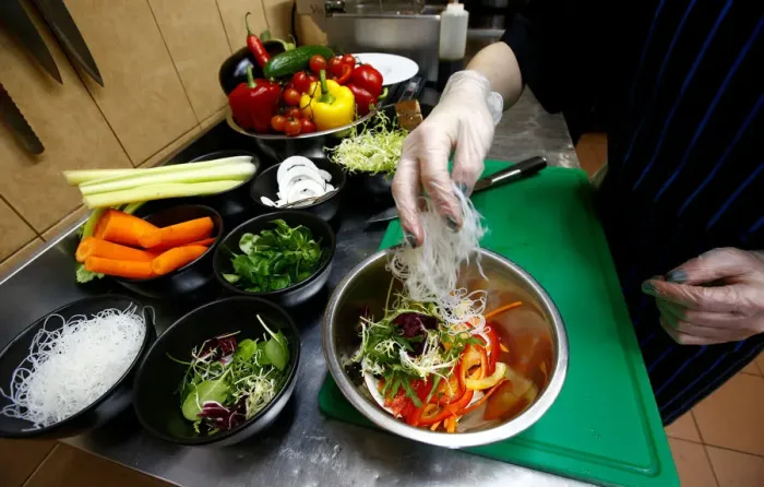 Framed Print : Employee prepares a salad in vegetarian restaurant Green Cuisine in Minsk