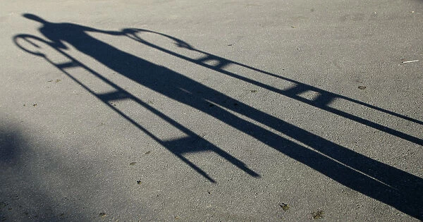 An employee of a traditional wooden sledge manufacturer casts his shadow in Boehen