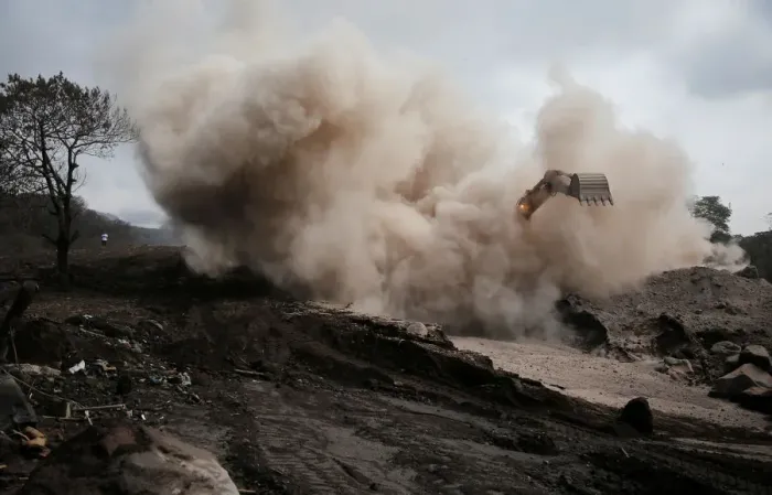 Framed Print : An excavator removes ash from an area affected by the eruption of Fuego volcano in San Framed Print : An excavator removes ash from an area affected by the eruption of Fuego volcano in San