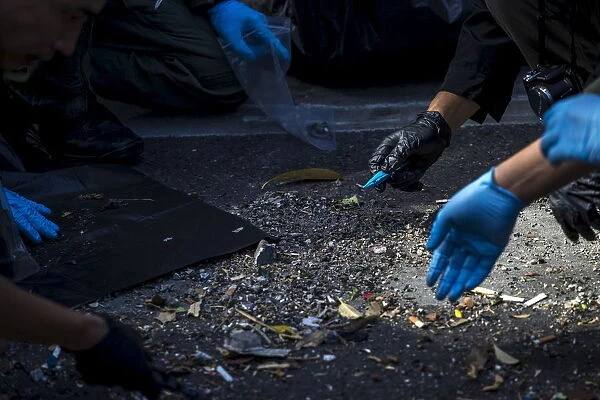 Experts investigate debris near the site of a deadly blast in central Bangkok