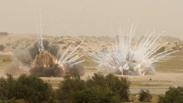 Explosions are seen while members of Hamas security forces work on neutralizing an