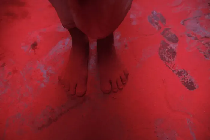 Framed Print : The feet of a man covered in red coloured powder are pictured during Holi celebrations in Framed Print : The feet of a man covered in red coloured powder are pictured during Holi celebrations in