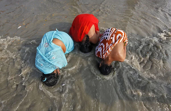 Female Hindu pilgrims take a dip at the confluence of the Ganges river