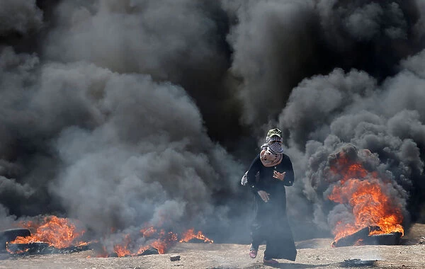 Female Palestinian demonstrator gestures during a protest against U. S