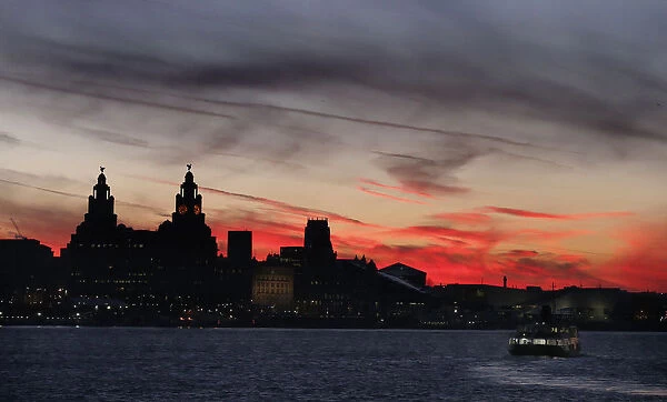 A ferry crosses the river Mersey during sunrise in Liverpool