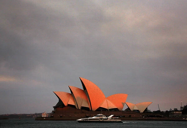 Ferry sails past the Sydney Opera House as smoke from bushfires can be seen above