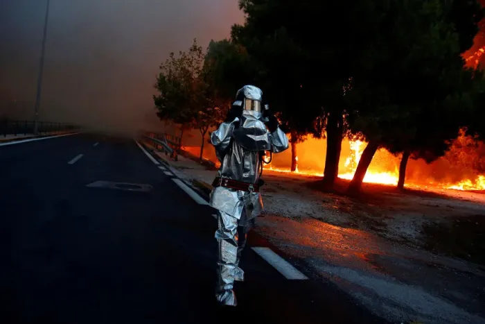 Framed Print : A firefighter wears a flame resistant uniform as wildfire burns in the town of Rafina
