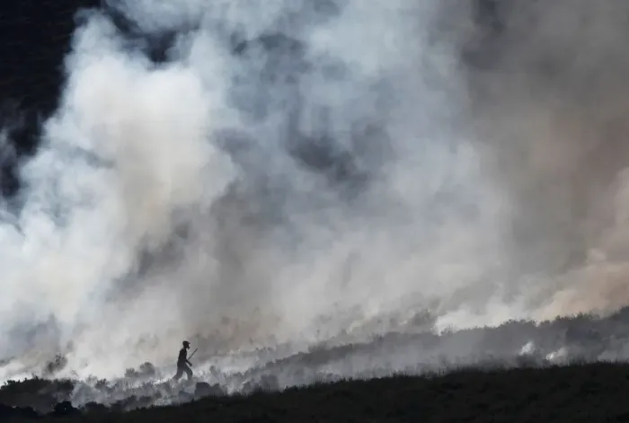 Framed Print : A firefighter works at fire on a moor above Carrwood Framed Print : A firefighter works at fire on a moor above Carrwood