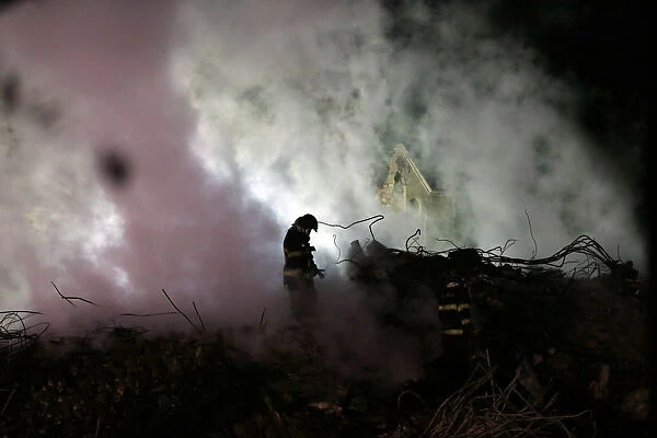 Firefighters work at the site where a building collapsed, in downtown Sao Paulo