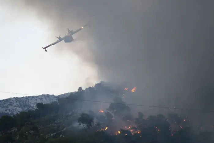 Framed Print : A firefighting plane drops water to extinguish a wildfire in the village of Mravince near Framed Print : A firefighting plane drops water to extinguish a wildfire in the village of Mravince near