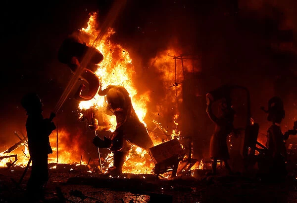 A fireman sprays water at figures of a monument as it burns during the finale of the