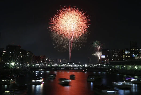Fireworks explode over high-rise buildings and Tokyos Sumida river during the Sumida