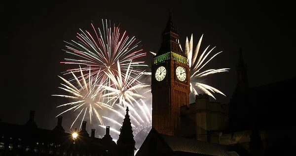 Fireworks explode behind the Houses of Parliament and Big Ben on the River Thames